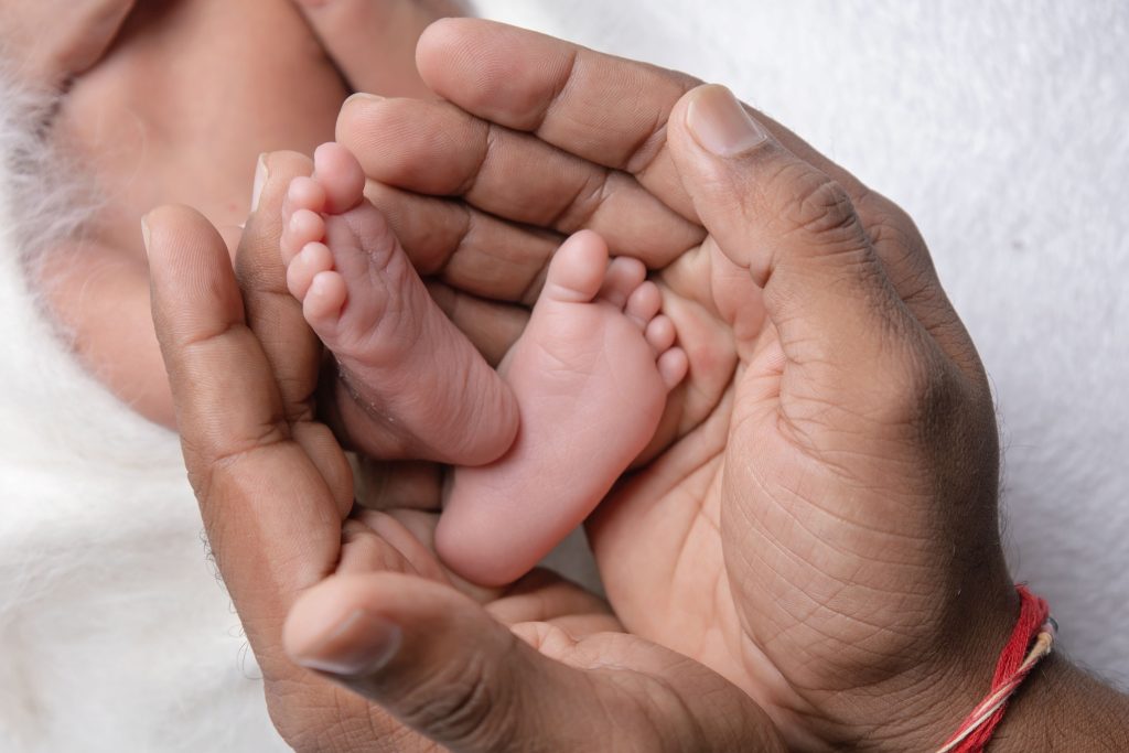 When Is the Best Time for a Newborn Photoshoot in Durban (And What If You Miss It?) Newborn baby feet in dad